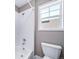 Bright bathroom featuring a toilet and shower and a window for natural light at 7720 S Queensburg Way, Aurora, CO 80016