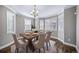 Dining room with neutral walls, hardwood floors, bay windows, and a chandelier at 7720 S Queensburg Way, Aurora, CO 80016