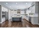 Bright kitchen features white cabinetry, stainless steel appliances, hardwood floors, and a gray island at 7720 S Queensburg Way, Aurora, CO 80016