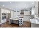 Bright kitchen features white cabinetry, stainless steel appliances, hardwood floors, and a gray island at 7720 S Queensburg Way, Aurora, CO 80016