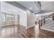 Spacious living room with hardwood floors, large windows, and adjacent staircase at 7720 S Queensburg Way, Aurora, CO 80016