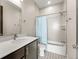 Bright bathroom showcasing stylish tile flooring, a tub, and a shower with a blue curtain at 1615 Harlan St # 2, Lakewood, CO 80214