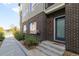 Inviting brick exterior with a blue front door and landscaped walkway at 1615 Harlan St # 2, Lakewood, CO 80214