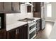 Close up of stainless steel appliances, white countertop and dark wood cabinets in a modern kitchen at 1615 Harlan St # 2, Lakewood, CO 80214