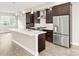 Bright kitchen featuring a large island, stainless steel appliances, and elegant dark wood cabinetry at 1615 Harlan St # 2, Lakewood, CO 80214