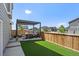 Private fenced backyard featuring a covered patio, artificial turf lawn and convenient access at 1100 Blue Bell Rd, Berthoud, CO 80513