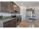 Modern kitchen with stainless steel appliances, granite countertops, ample storage, and wood-style flooring at 1100 Blue Bell Rd, Berthoud, CO 80513