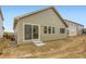 Backyard view of the home with sliding door, showing newly constructed dirt yard at 4102 Estrella St, Brighton, CO 80601