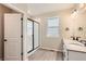 Bright bathroom features a double sink vanity, a glass shower and a window for natural light at 4102 Estrella St, Brighton, CO 80601