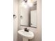The bathroom features a sleek, modern pedestal sink with a black faucet and a stylish rectangular mirror at 4102 Estrella St, Brighton, CO 80601