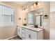 Bathroom featuring double sink vanity with a large mirror, modern lighting fixtures and black hardware at 4102 Estrella St, Brighton, CO 80601