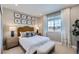 Cozy bedroom with neutral tones, stylish headboard, ample natural light, and decorative wall art at 4102 Estrella St, Brighton, CO 80601