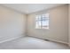 A sunlit bedroom features neutral walls, plush carpeting, and a window overlooking a new construction site at 4102 Estrella St, Brighton, CO 80601