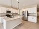 Well-lit kitchen with white cabinets, stainless steel appliances, and modern pendant lighting at 4102 Estrella St, Brighton, CO 80601