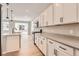 The kitchen boasts white cabinetry, stainless steel appliances, and island with faucet, with sliding door to the outside at 4102 Estrella St, Brighton, CO 80601