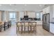 Bright, open kitchen with stainless steel appliances, a kitchen island with barstool seating, and modern cabinetry at 4102 Estrella St, Brighton, CO 80601