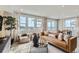 Bright living room with a sleek leather sofa, decorative rug, and large windows offering scenic outdoor views at 4102 Estrella St, Brighton, CO 80601