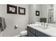 Modern bathroom features a white countertop, gray vanity, decorative art, and a shower with glass doors at 5839 Hay Market Trl, Parker, CO 80134