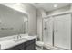 Modern bathroom featuring a glass-enclosed shower and a vanity with a large mirror at 5839 Hay Market Trl, Parker, CO 80134