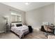 Comfortable bedroom with a cozy bed, a side table, a lamp, and a window for natural light at 5839 Hay Market Trl, Parker, CO 80134