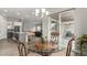 Bright dining area adjacent to kitchen and living room, with glass table and sliding doors at 5839 Hay Market Trl, Parker, CO 80134