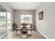Cozy dining area features a glass table, modern chandelier and natural light from the window at 5839 Hay Market Trl, Parker, CO 80134
