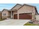 Beautiful home exterior with a two-car garage, stone accents, and well-maintained landscaping at 5839 Hay Market Trl, Parker, CO 80134