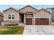 Charming home exterior with well-manicured lawn, stone accents, and a two-car garage for ample parking at 5839 Hay Market Trl, Parker, CO 80134