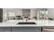 This large kitchen island features a built-in sink with a view of the dining and living areas at 5839 Hay Market Trl, Parker, CO 80134
