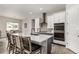 Modern kitchen features a large island with seating and white cabinets with stainless steel appliances at 5839 Hay Market Trl, Parker, CO 80134