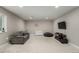 Basement living room with gray sofa, desk, television and modern decor at 5839 Hay Market Trl, Parker, CO 80134