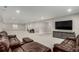 Large finished basement living room with a brown leather sofa set and entertainment center at 5839 Hay Market Trl, Parker, CO 80134