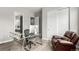 Home office with glass desk, chair, and brown leather recliner near a large closet, providing an organized workspace at 5839 Hay Market Trl, Parker, CO 80134