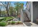 Exterior stairway leading to an upper-level entrance, surrounded by mature trees and lush greenery at 8500 E Jefferson Ave # 11C, Denver, CO 80237