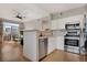 Modern kitchen with stainless steel appliances, white cabinets, and an open view to the living room at 8500 E Jefferson Ave # 11C, Denver, CO 80237