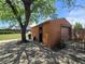 A charming detached garage with a wooden gate, on a sunny day with ample shade from a mature tree at 7371 Granada Rd, Denver, CO 80221
