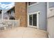 A concrete patio with a brick chimney, white fence, and sliding glass doors providing a private outdoor space at 2856 S Kenton Ct, Aurora, CO 80014