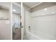 Bathroom with white tiled shower over tub and an open doorway at 2856 S Kenton Ct, Aurora, CO 80014