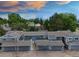 Exterior view of townhomes featuring garages, and mature landscaping, set against a colorful sky at sunset at 2856 S Kenton Ct, Aurora, CO 80014