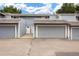 Exterior view of the townhome with gray siding, attached garages, and well-maintained landscaping at 2856 S Kenton Ct, Aurora, CO 80014