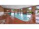 Well-lit indoor pool area with large windows, brick accents, and lounge chairs for relaxation at 2856 S Kenton Ct, Aurora, CO 80014