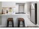 Modern kitchen featuring white cabinets, stainless steel refrigerator, and a breakfast bar with seating for two at 2856 S Kenton Ct, Aurora, CO 80014