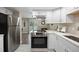 Bright kitchen featuring stainless steel appliances, white cabinetry and a fireplace view at 2856 S Kenton Ct, Aurora, CO 80014