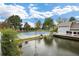 A beautiful view of a tennis court and pond under a sunny sky with clouds overhead at 2856 S Kenton Ct, Aurora, CO 80014
