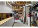 Unfinished basement with painted floors, exposed wood beams, shelving, and storage space at 7645 Fox Creek Trl, Franktown, CO 80116