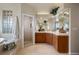 Bright bathroom features double sink, large mirrors, glass block window, shower and bath tub at 7645 Fox Creek Trl, Franktown, CO 80116