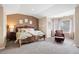 Spacious bedroom featuring a large bed with a decorative headboard, a seating area, and plenty of natural light at 7645 Fox Creek Trl, Franktown, CO 80116