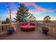 Outdoor deck area with a round sofa, colorful pillows, and scenic views at 7645 Fox Creek Trl, Franktown, CO 80116