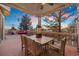 Spacious deck featuring outdoor dining set with seating for six, ceiling fan, and string lights at 7645 Fox Creek Trl, Franktown, CO 80116