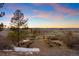 Outdoor event space at sunset with rustic benches, mountain views, and a wooden gate entrance on an open field at 7645 Fox Creek Trl, Franktown, CO 80116